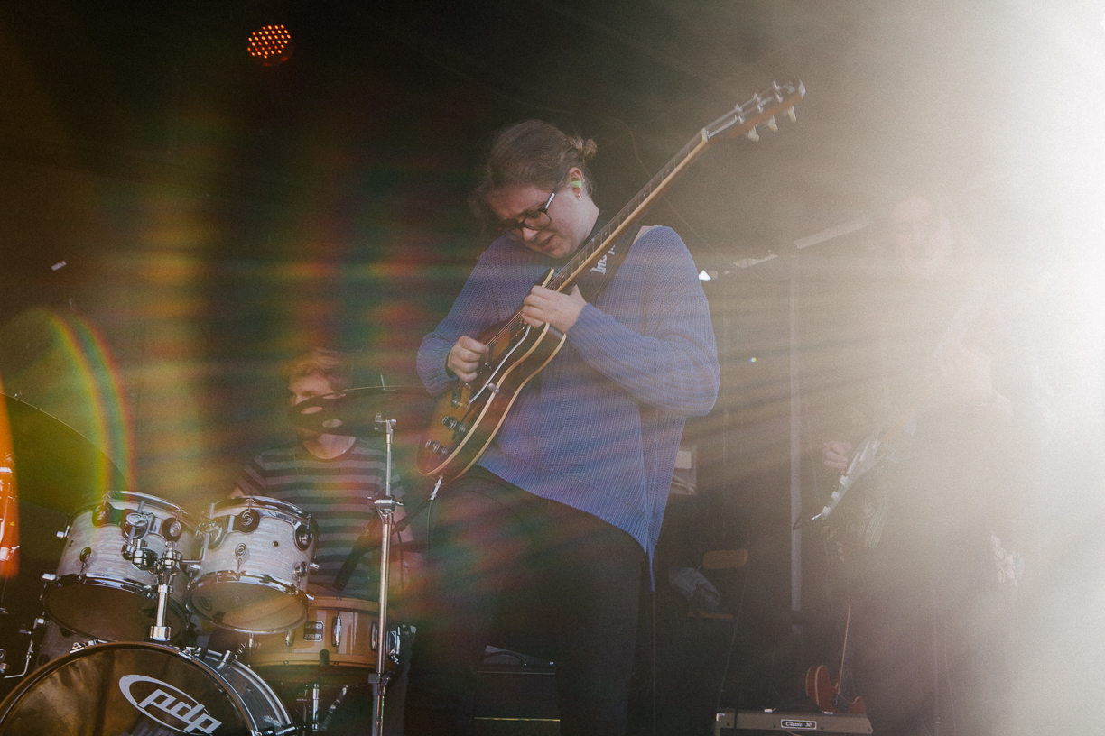 Charlotta Andersson in center of image, playing guitar.