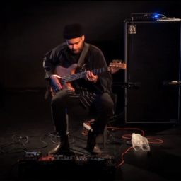 Cassius Lambert is sitting with his bass on his lap.